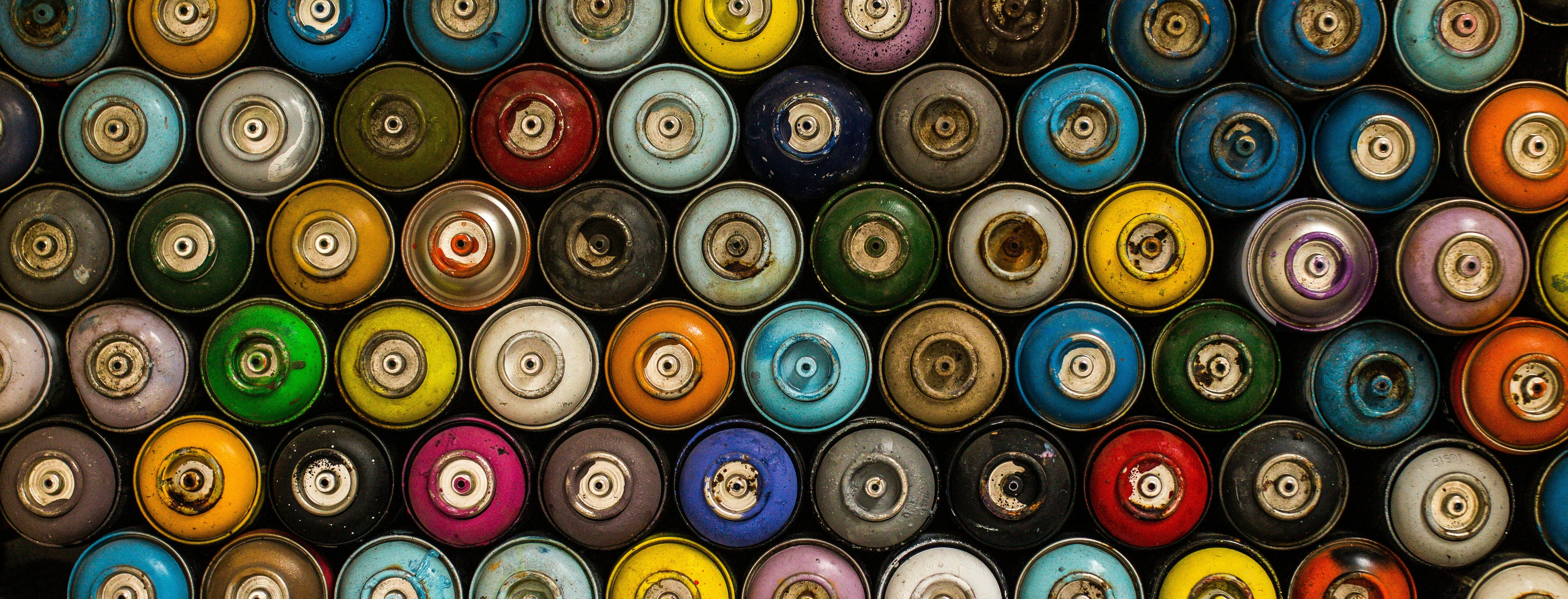 A bunch of spray paint cans stacked on top of each other